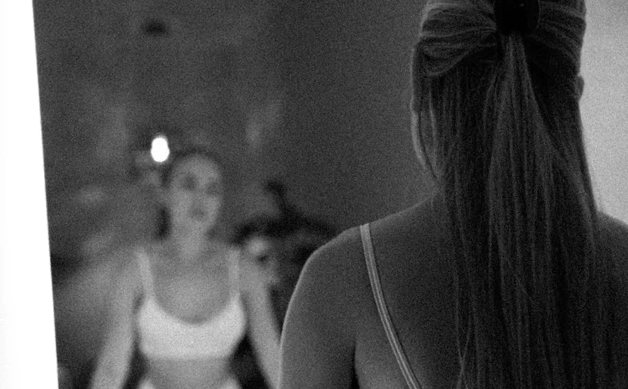 Client in activewear standing at a mirror in the LIMFAERA studio
