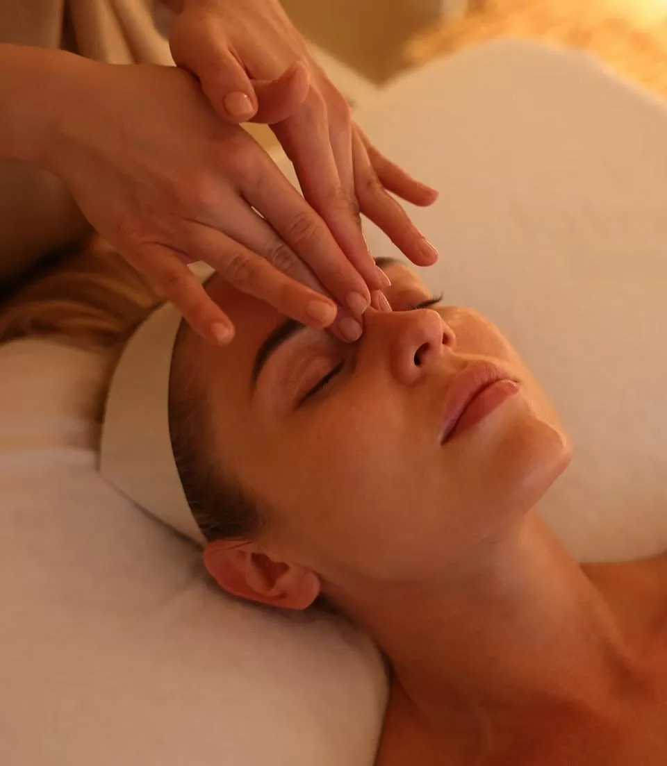 Specialist's hands resting on a relaxed client's face during a consultation at LIMFAERA in Beverly Hills