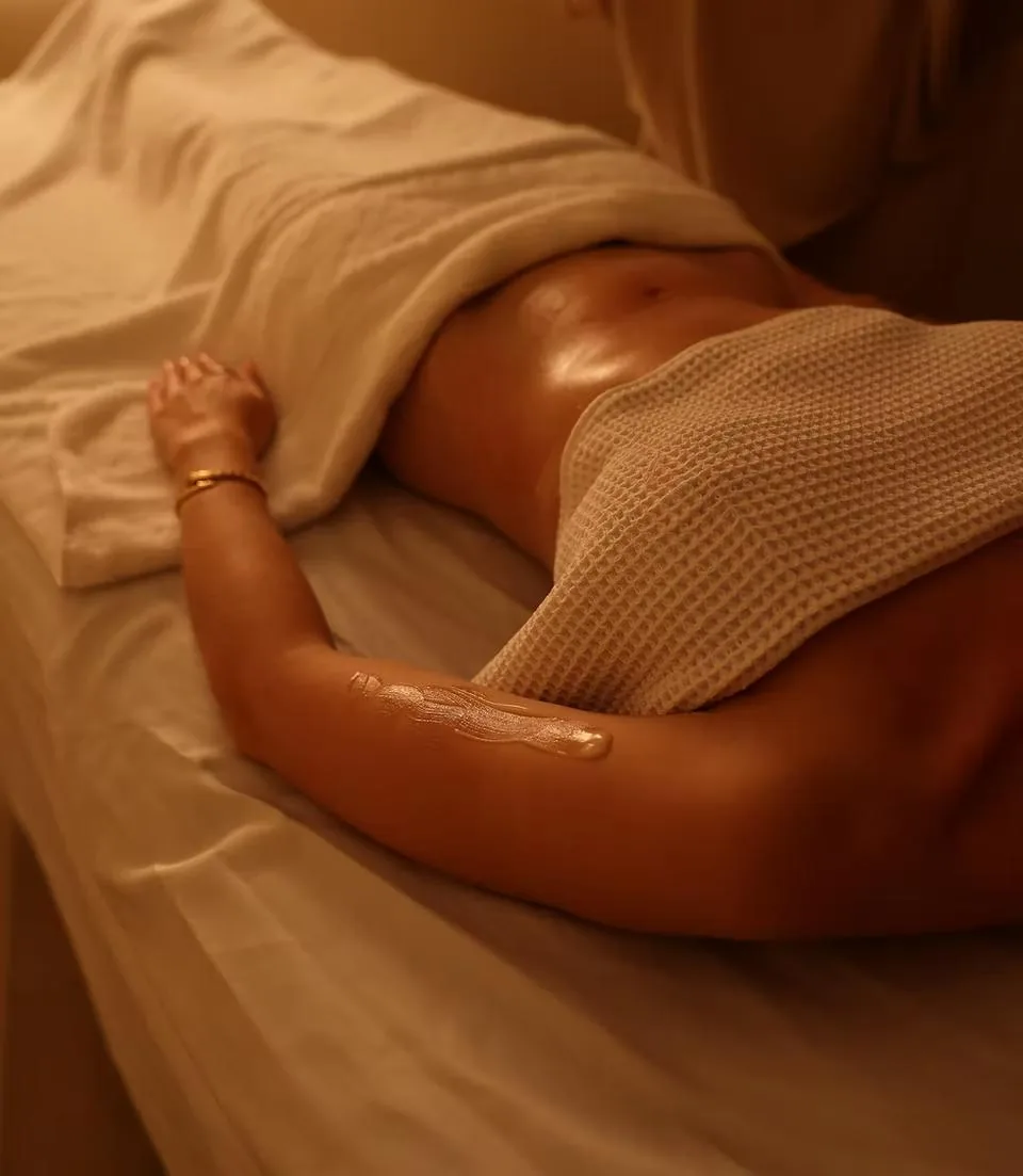 Client resting on a massage table under a waffle towel during a Linfomodellante® manual body contouring session