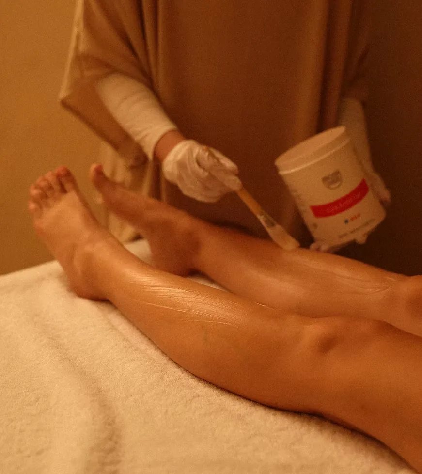 Therapist in gloves applying a contouring preparation to the legs before a LinfoModellante® legs session